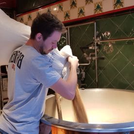 Employé versant le malt pour créer de la bière artisanale